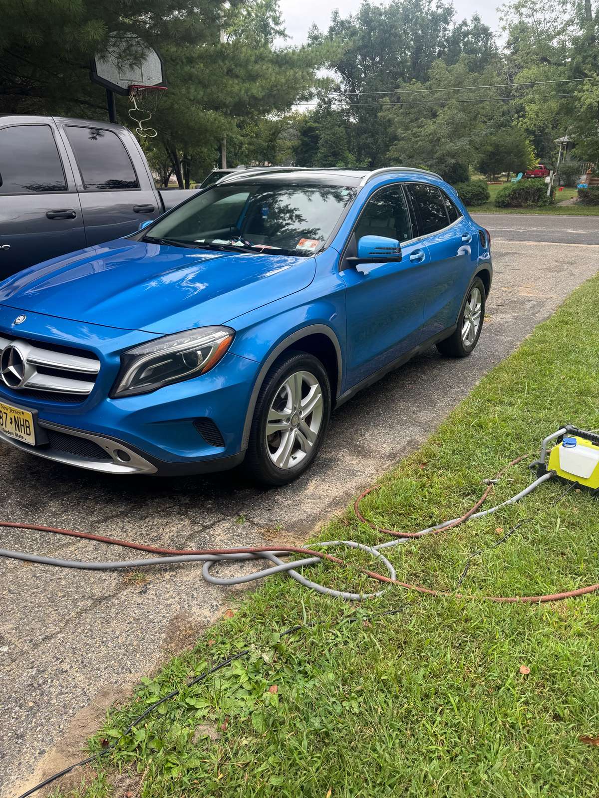Bright blue Mercedes-Benz GLA exterior after detailing, glossy paint with silver wheels on a residential driveway.